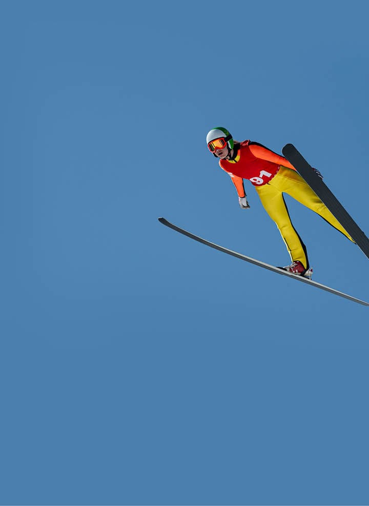 Front view of young female ski jumper during the long ski jump