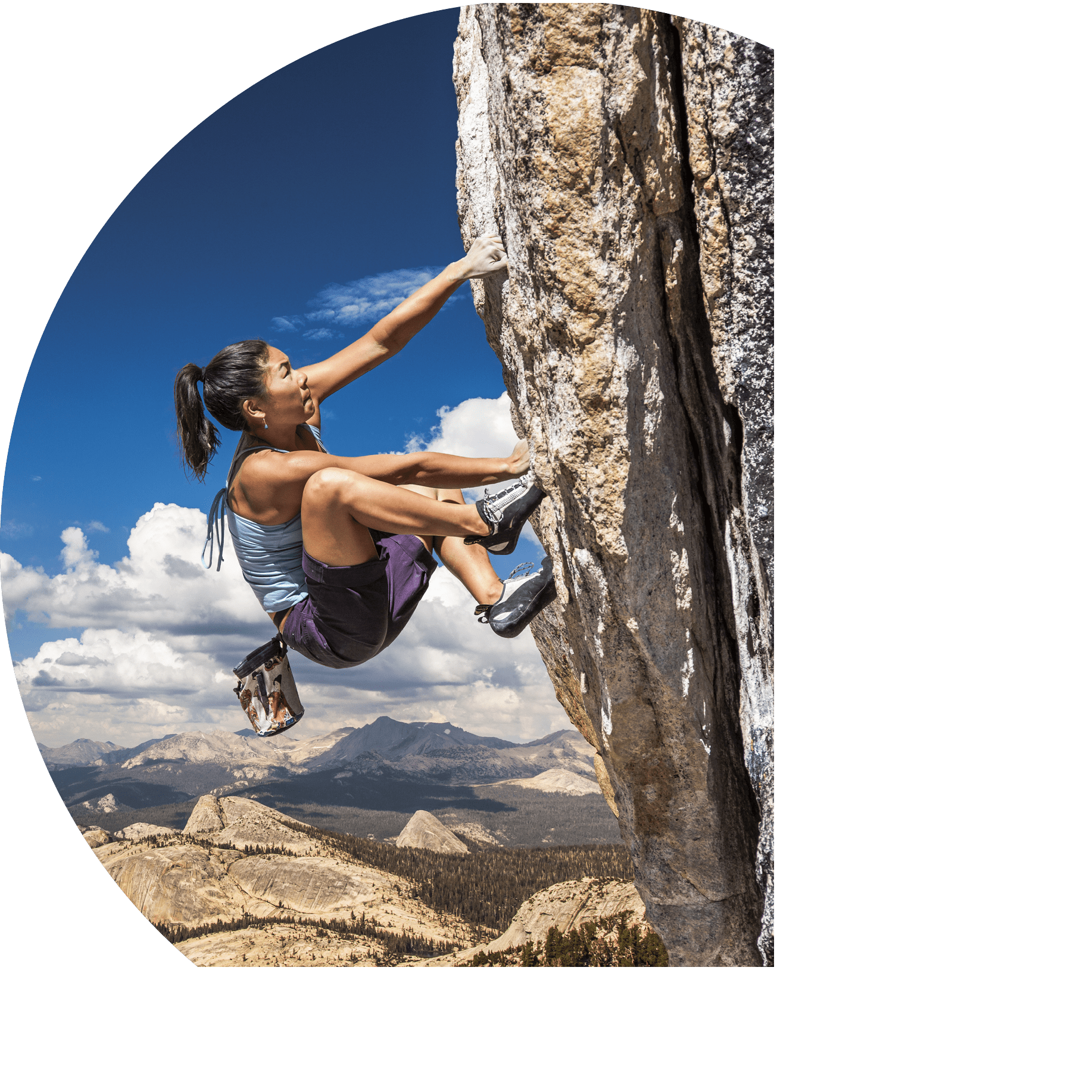 Female climber dangles from the edge of a challenging cliff 