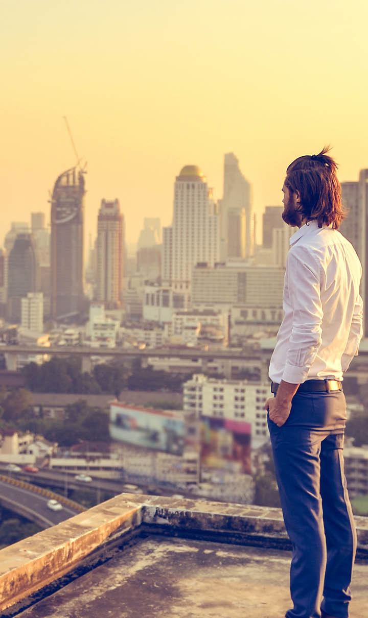 Western businessman looking at the city at sunset