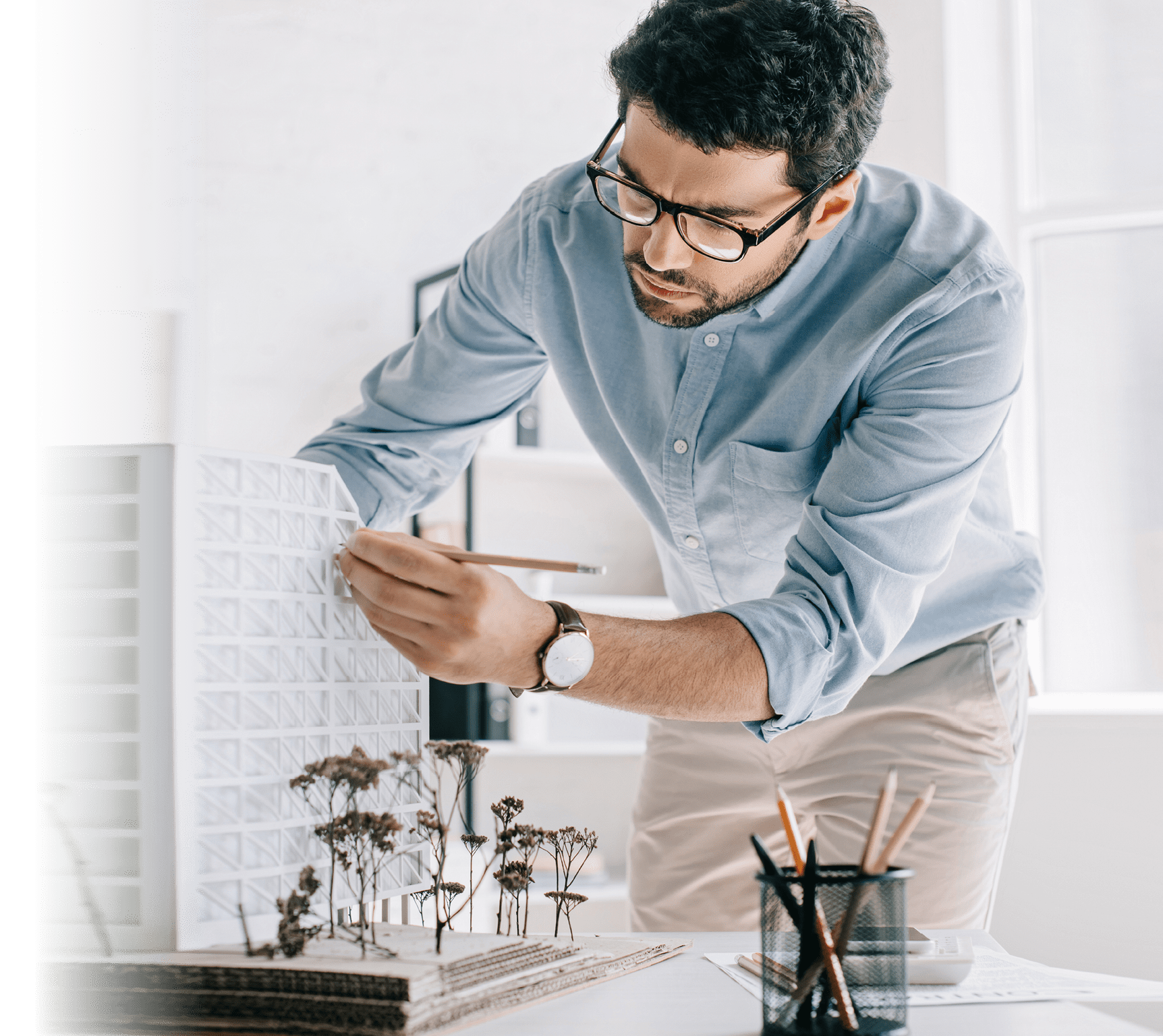 handsome architect working with architecture model on table in office