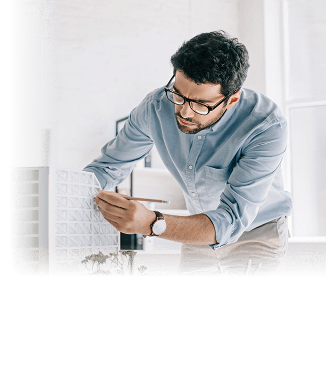 handsome architect working with architecture model on table in office