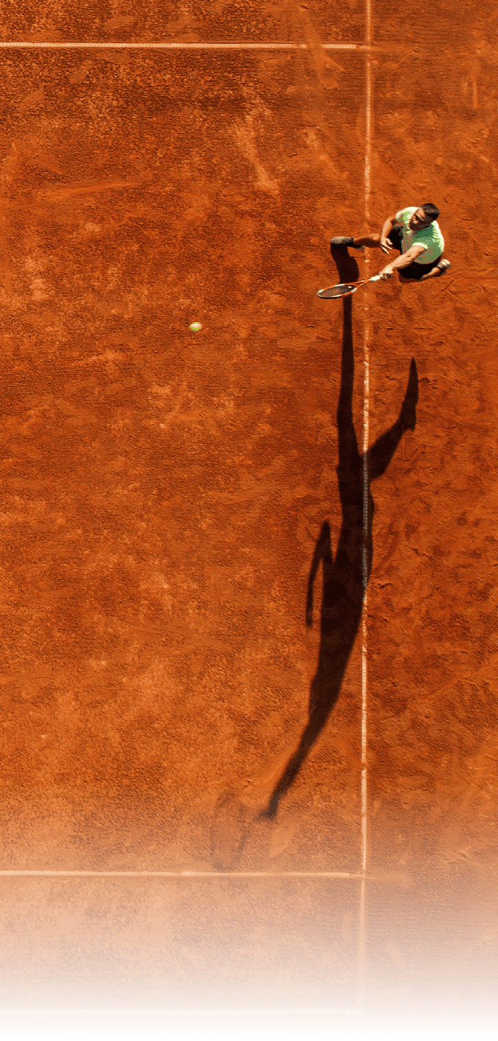 One part of tennis clay court with one man player only  He is mature adult, and very agile and healthy  Photo made with drone, directly above 