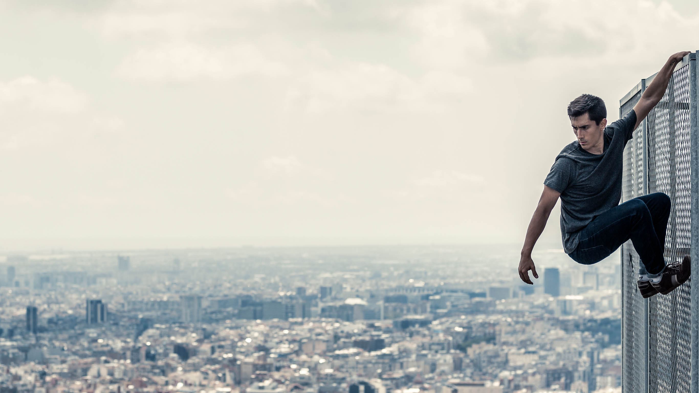 Urban parkour Man climbing fence