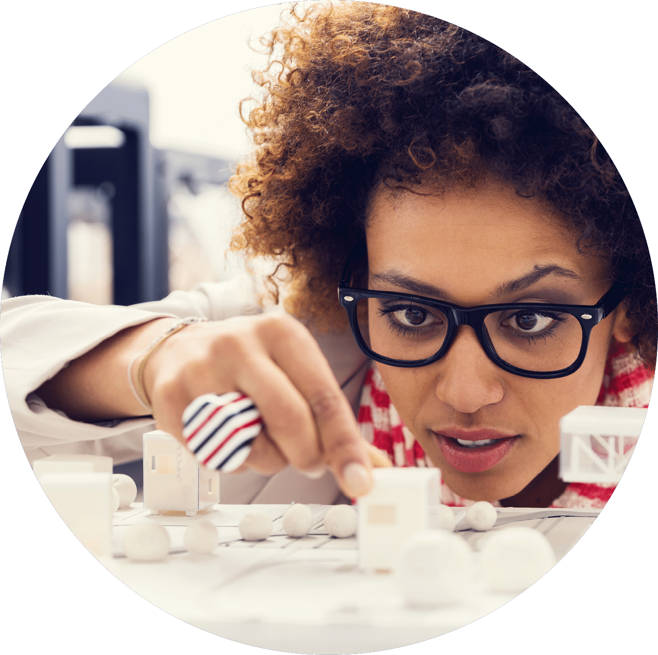 Close up of mixed race young architect sitting in a 3D printer office and watching 3D printings 